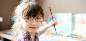Malendes Kind mit BrilleCute little girl painting